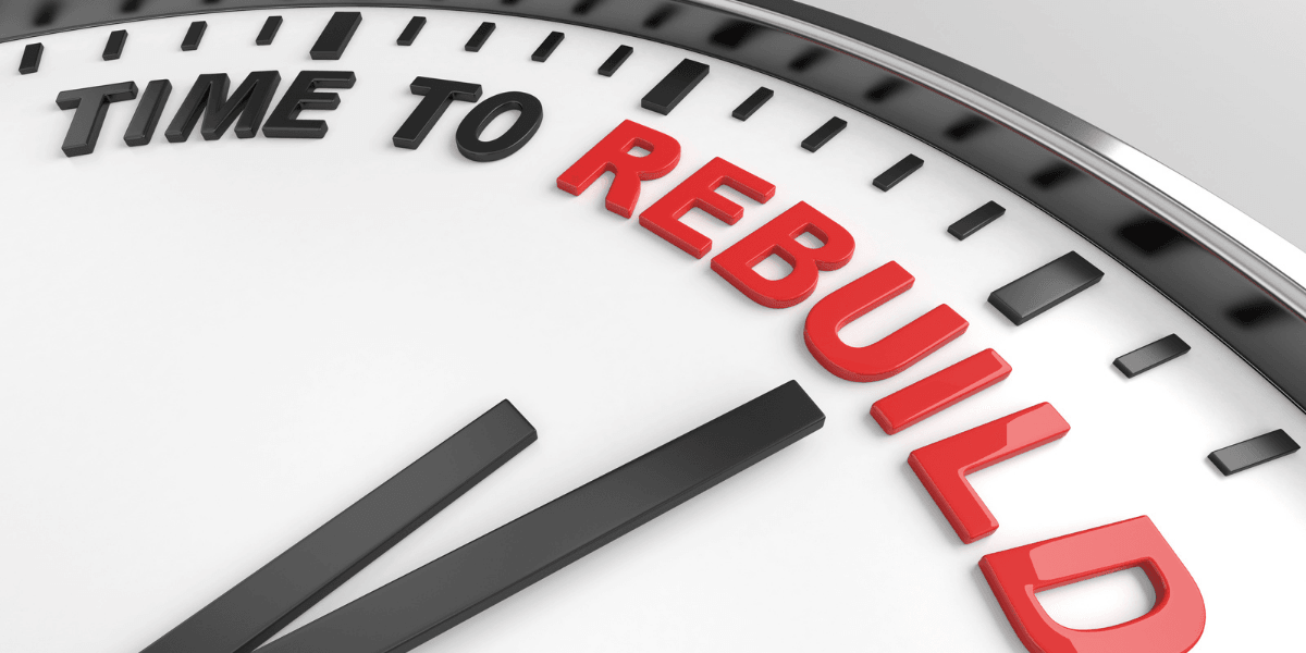 Close-up of a clock face showing "TIME TO REBUILD" in red letters