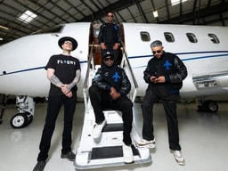 Flight Bernal Heights team posing on private jet stairs inside an aircraft hangar.
