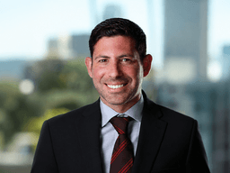 Smiling man in a suit with a blurred city background
