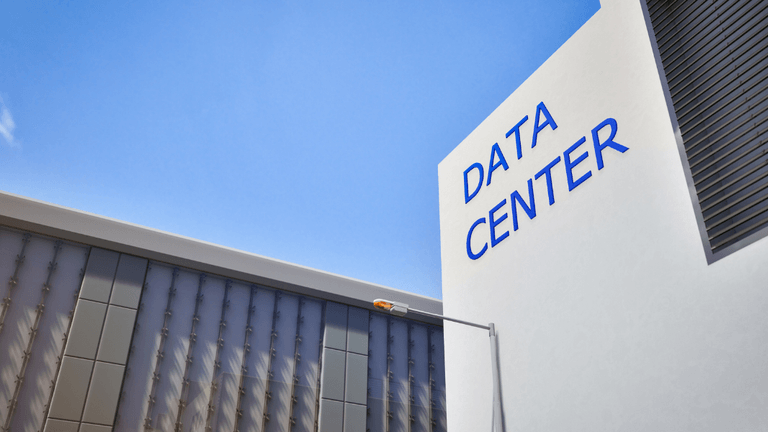 Exterior view of a modern data center building under a clear blue sky