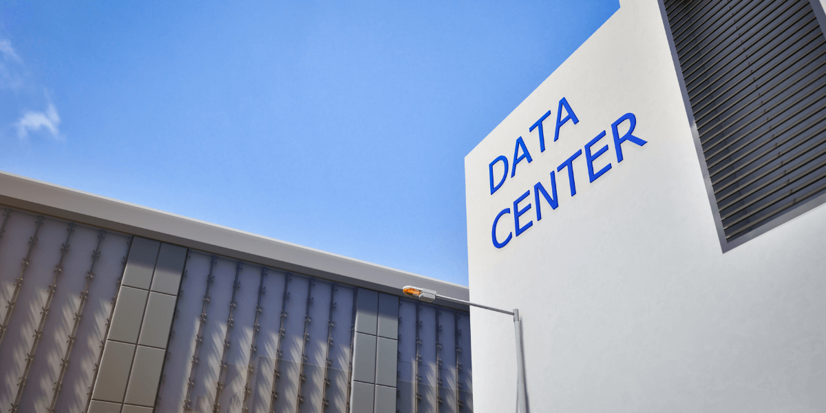 Exterior view of a modern data center building under a clear blue sky