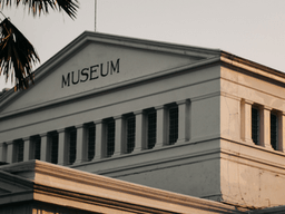 Historic museum building with a prominent sign and classic architectural features