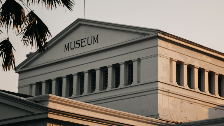 Historic museum building with a prominent sign and classic architectural features
