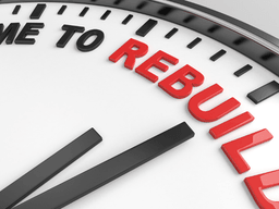 Close-up of a clock face showing "TIME TO REBUILD" in red letters