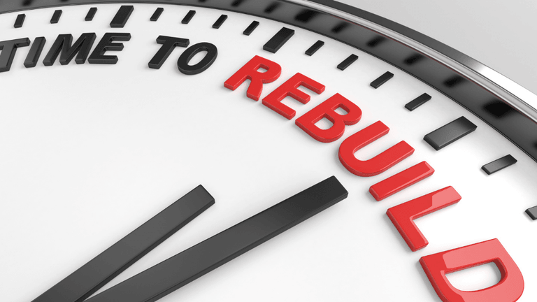 Close-up of a clock face showing "TIME TO REBUILD" in red letters