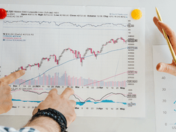 Two people analyzing a stock market chart with graphs and notes on a board