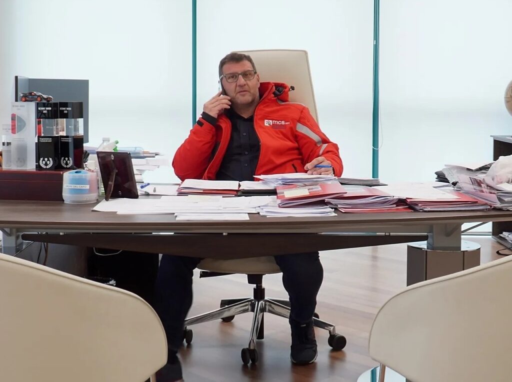 Massimo Locatelli seated at his office desk speaking on the phone at MCS headquarters.